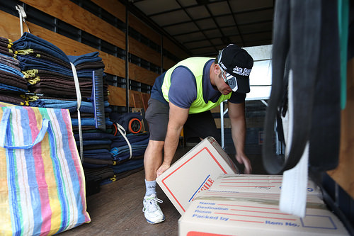 Removal Firm Member Lifting A Box Inside The Truck Photo