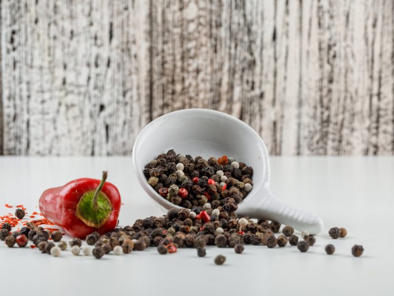 Mixed Peppercorns Plate With Red Pepper Side View White Wooden Grunge Wall