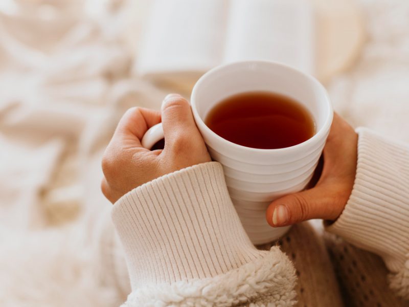 Young Woman Holding Cup Tea While Enjoying Winter Holidays