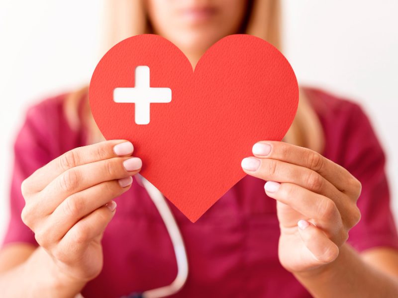 Defocused Female Doctor Holding Paper Heart