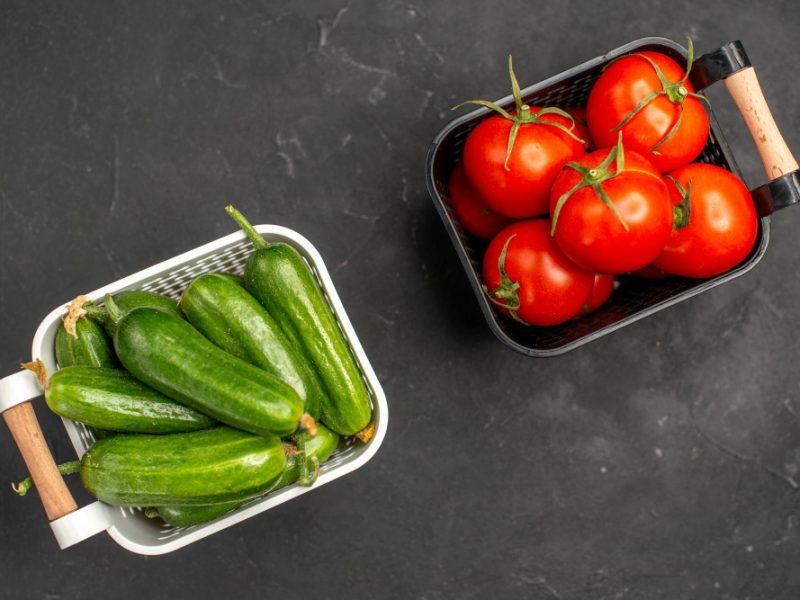 Top View Fresh Red Tomatoes With Cucumbers Inside Baskets Dark Background