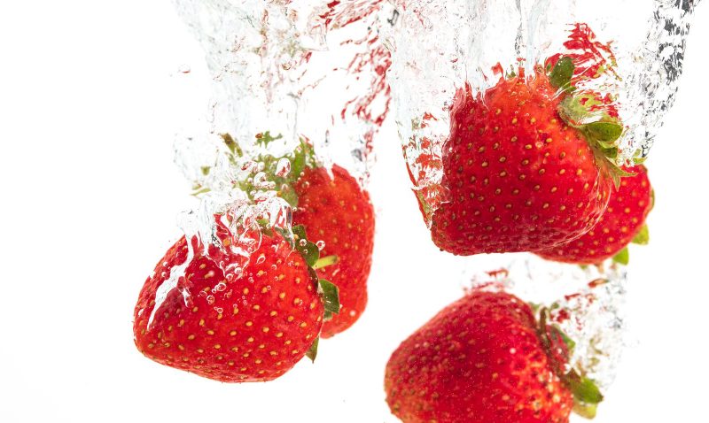 Strawberries Falling Into Water Causing Bubbles All Around It Healthy Food Concept