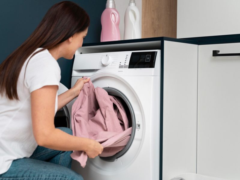 Woman Taking Clothes From Washing Machine