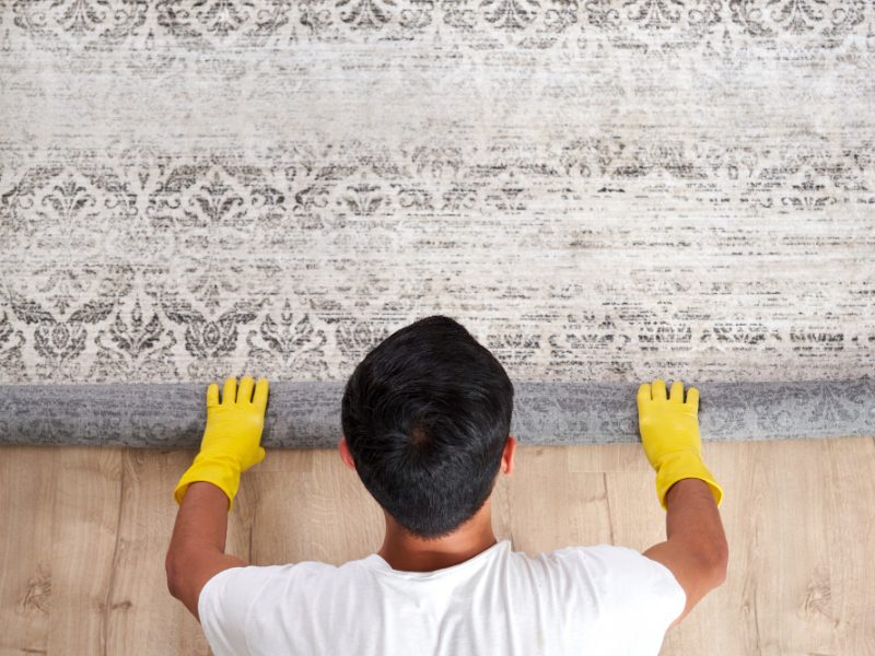 High Angle View Man Unrolling Carpet Cleaning Service Concept