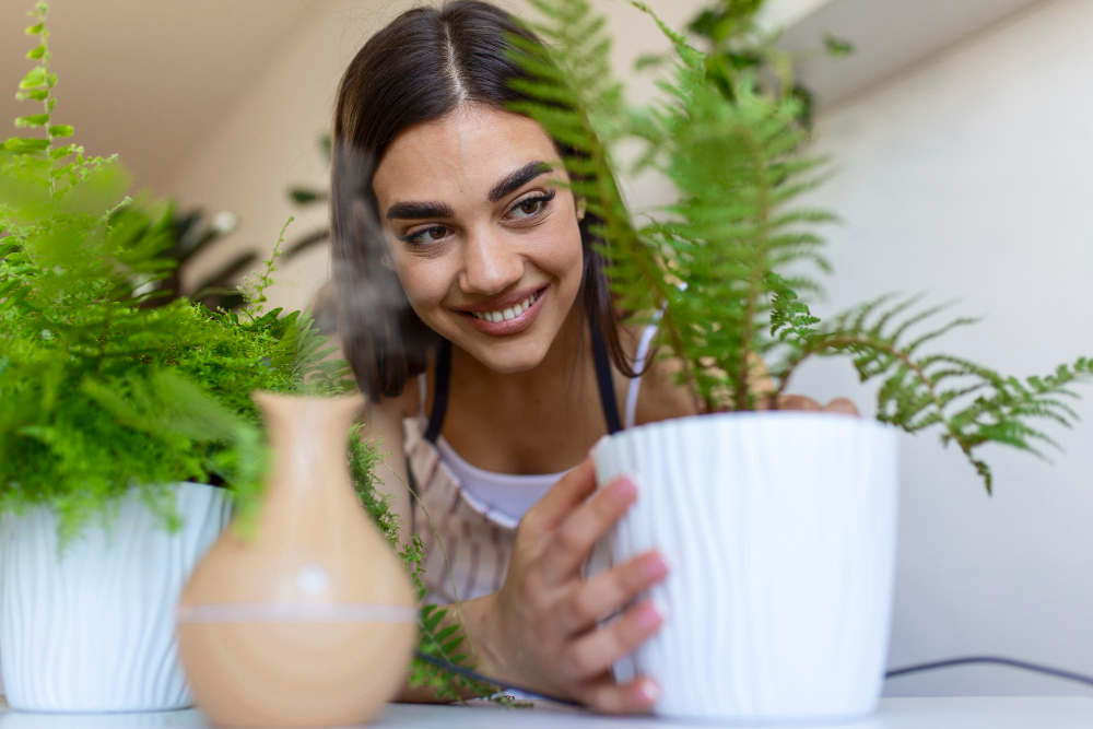 joyful-young-woman-enjoys-her-time-home-watering-her-plant-by-window-home