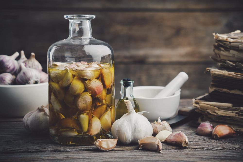 garlic-aromatic-flavored-oil-infusion-bottle-garlic-cloves-mortar-recipe-books-kitchen-knife