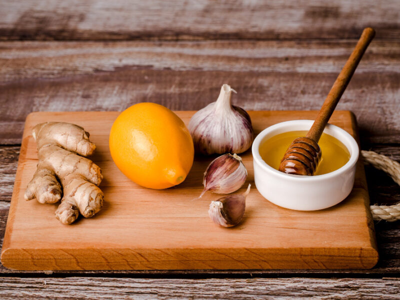 Healthy Food Immunity Kit Vitamin C Honey Ginger Root Lemon Garlic Wood Board Brown Background