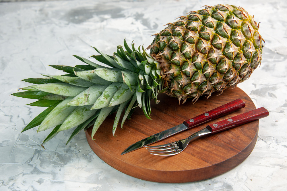 Front View Whole Fresh Golden Pineapple Fork Knife Cutting Board Marble Surface