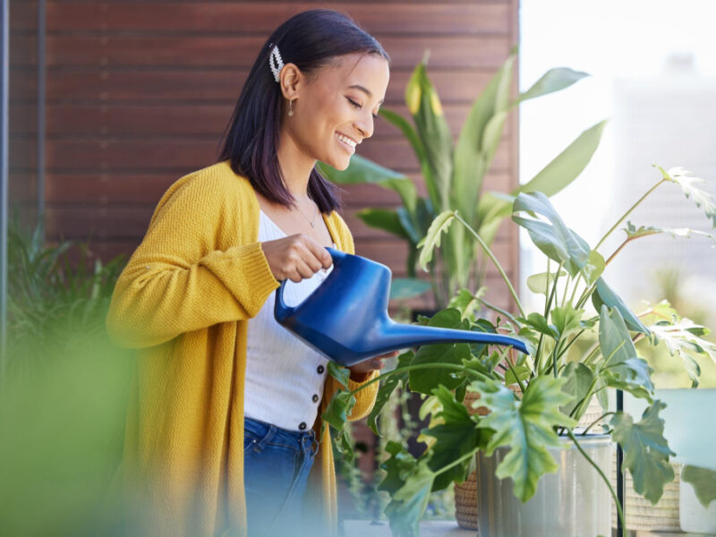 When You Take Care Things They Grow Shot Young Woman Watering Her Plants Balcony Home