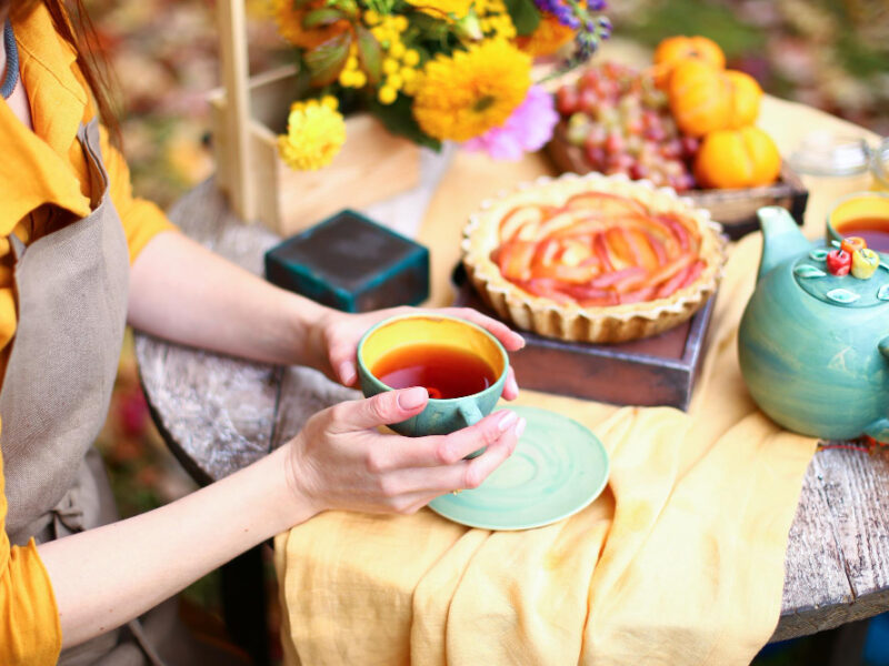 Autumn Picnic Woman Yellow Dress Linen Apron Drinks Tea From Cup Wooden Table Garden Beautiful Kettle Tablecloth Honey With Spoon Apple Pie Harvest Persimmon Grapes Maple Leaf