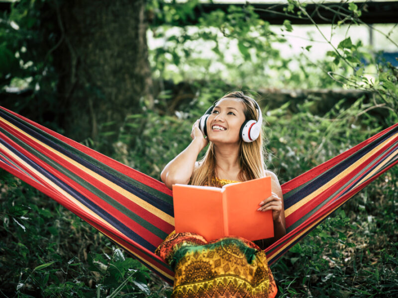 Beautiful Happy Young Woman With Headphones Listening Music Reading Book