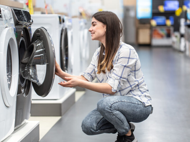 Young Woman Store Chooses Washing Machine