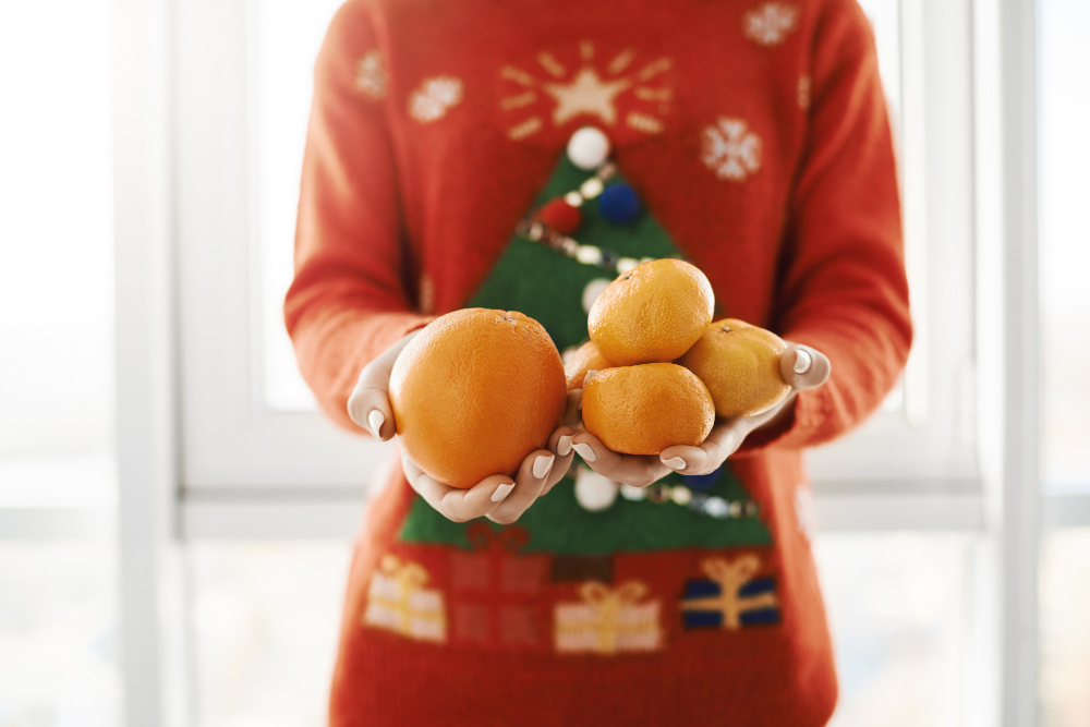 New Year Winter Concept Cropped Shot Female Funny Christmas Sweater Holding Orange Tangerines Offering It Friend Standing Near Window Girl Got Ill Boyfriend Brought Vitamin C