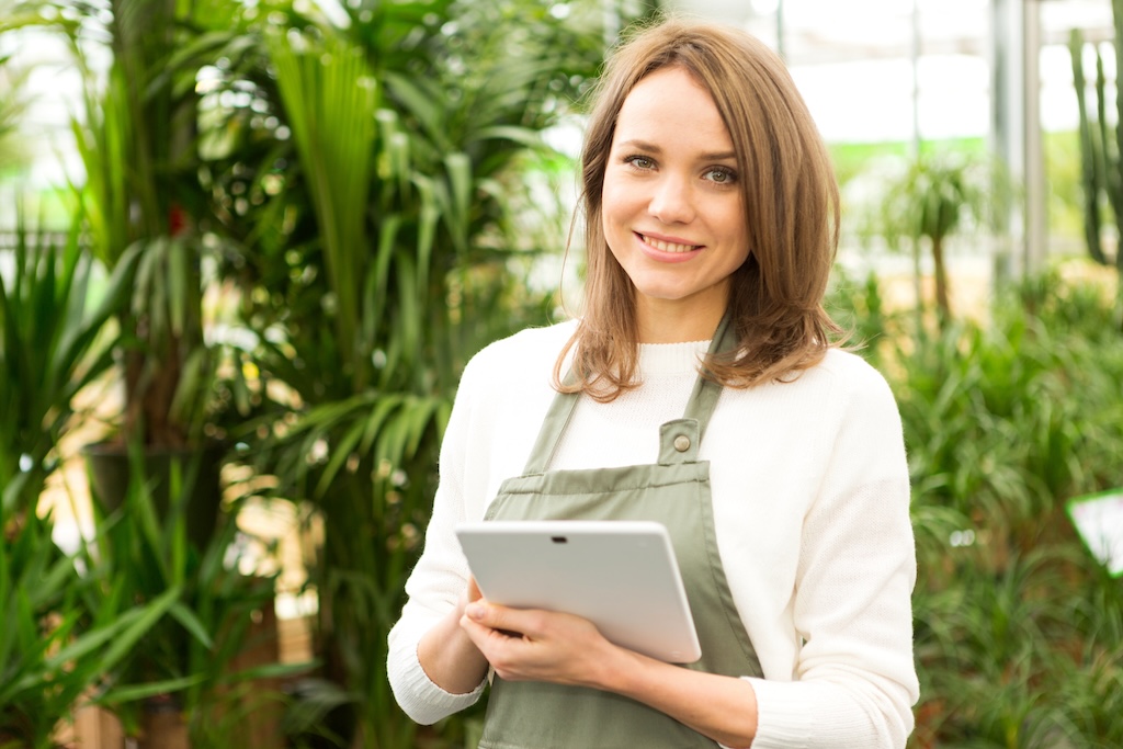 Young Attractive Woman Working At The Plants Nursery Using Tablet
