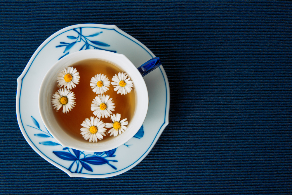 aromatic-chamomile-tea-cup-sauce-dark-placemat-background-flat-lay