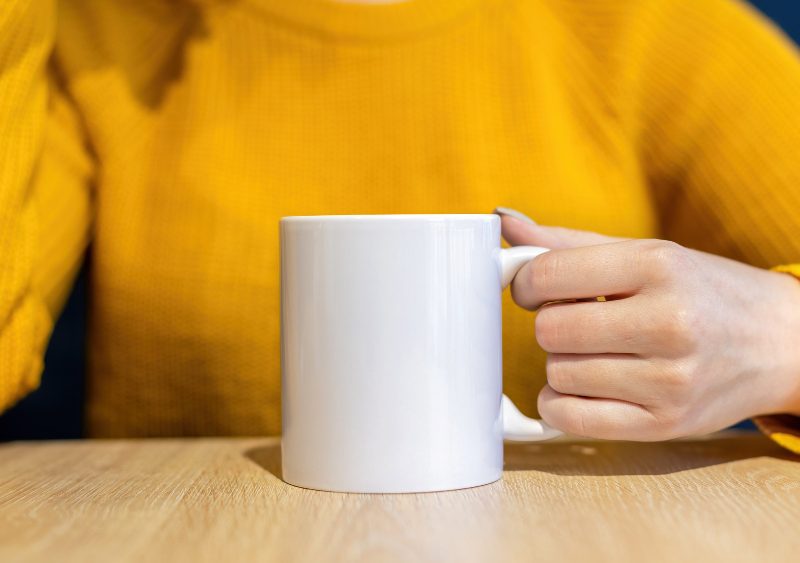 Woman Sweater Holding Cup Wooden Table