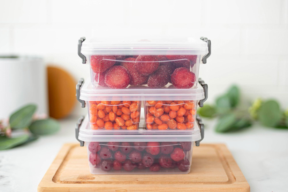 Three Plastic Containers With Frozen Berries Kitchen Table Closeup