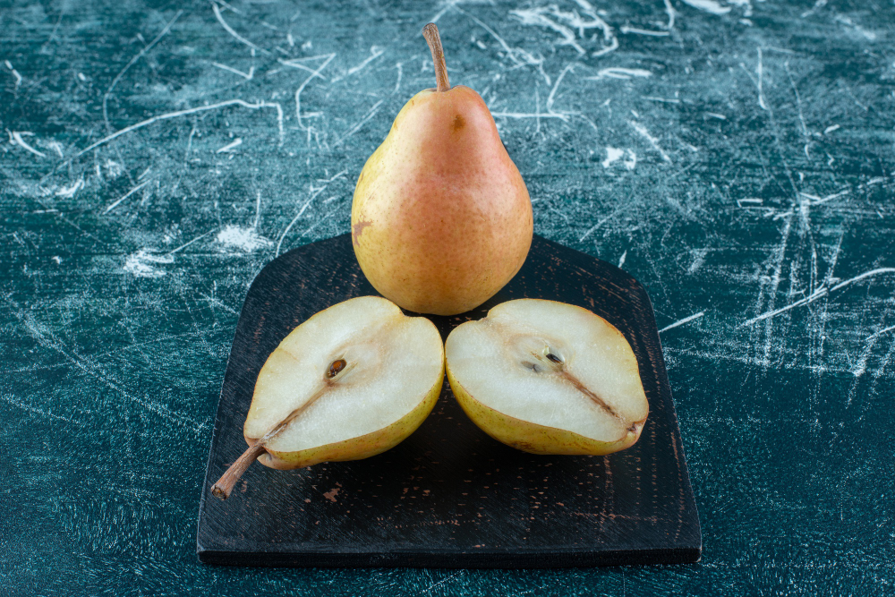 two-pieces-pears-board-blue-background-high-quality-photo