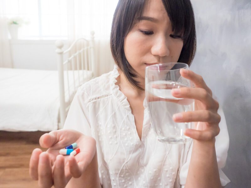 Asian Young Woman Holding Glass Water Pills