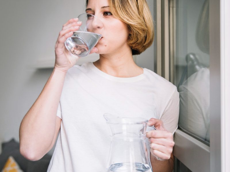 Woman Drinking Water Near Window